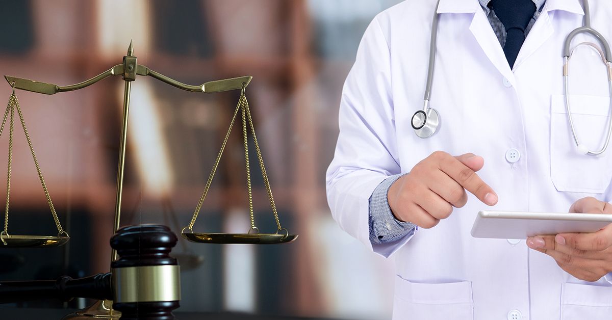 Medical doctor with scales of justice and gavel in the foreground